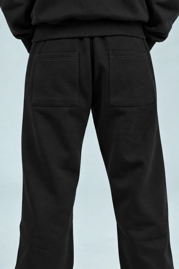 Black baggy sweatpants with side pockets and stitched panel detail